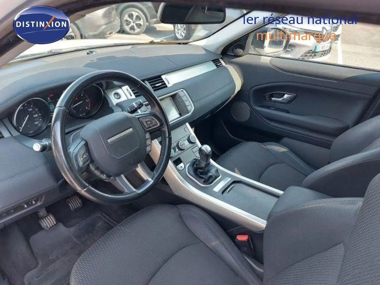 Intérieur noir du Range Rover Evoque 2018 vu côté conducteur, avec tableau de bord et boîte manuelle visibles.