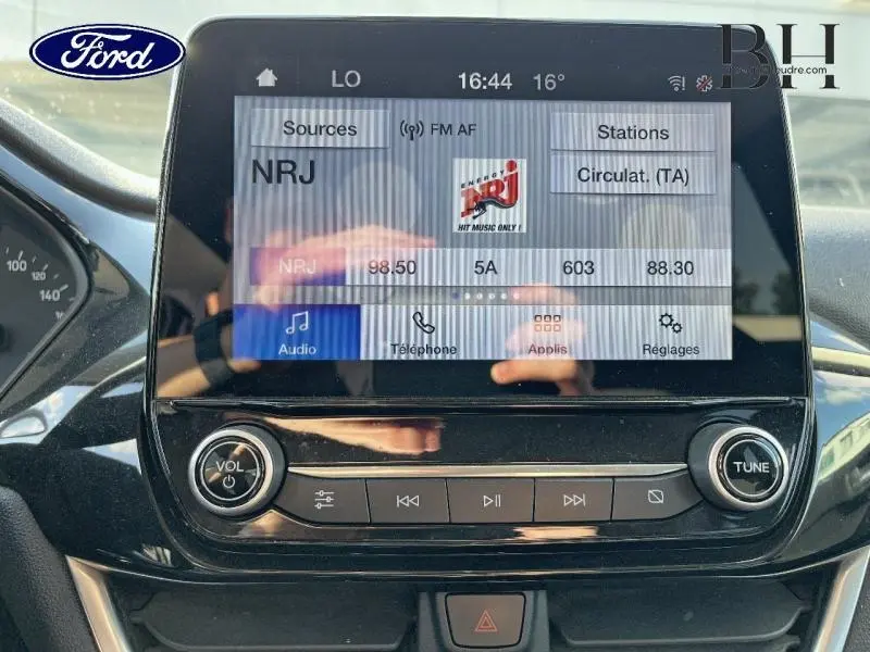 Écran tactile central de la Ford Fiesta 2021 en Fashion Gris, affichant la radio NRJ avec commandes audio intégrées.