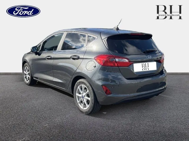 Ford Fiesta 1.1 Titanium 2021 en Fashion Gris Magnetic vue 3/4 arrière droit avec vitres arrière surteintées et jantes alu.