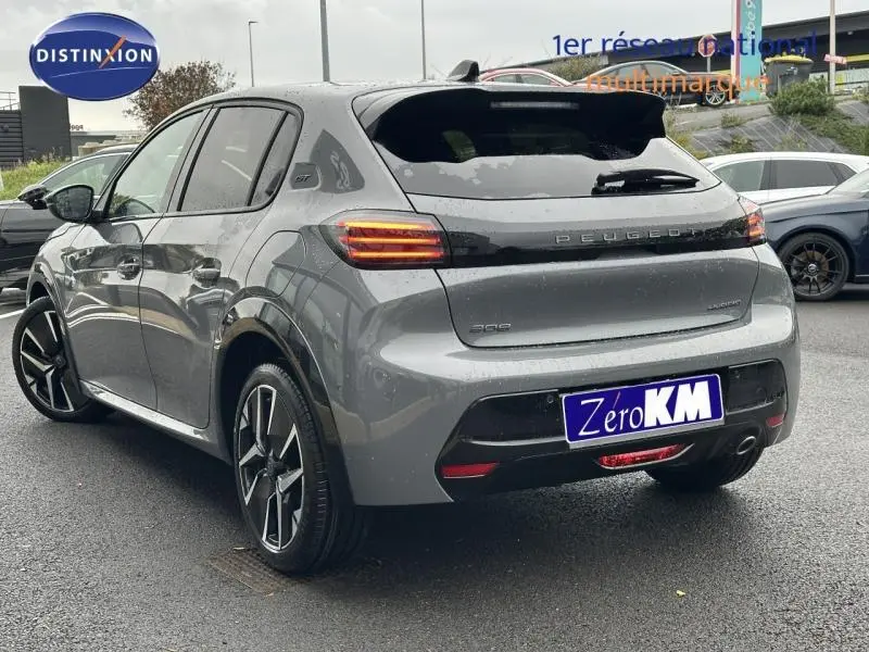 Vue 3/4 arrière droite d'une Peugeot 208 grise 1.2 Hybrid 110ch GT avec feux arrière LED et jantes alliage.