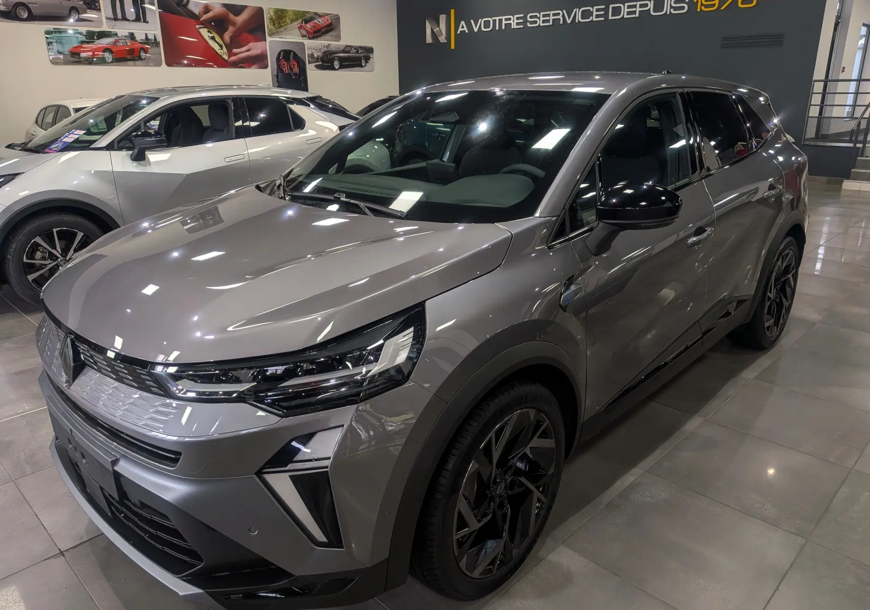 Vue 3/4 avant droite d'une Renault SYMBIOZ gris Cassiopé avec jantes noires et éclairage LED en showroom.
