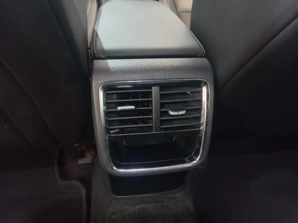 Gros plan sur la sortie d'air arrière centrale avec cadre chromé et console noire dans une Skoda Octavia bleue 2022.