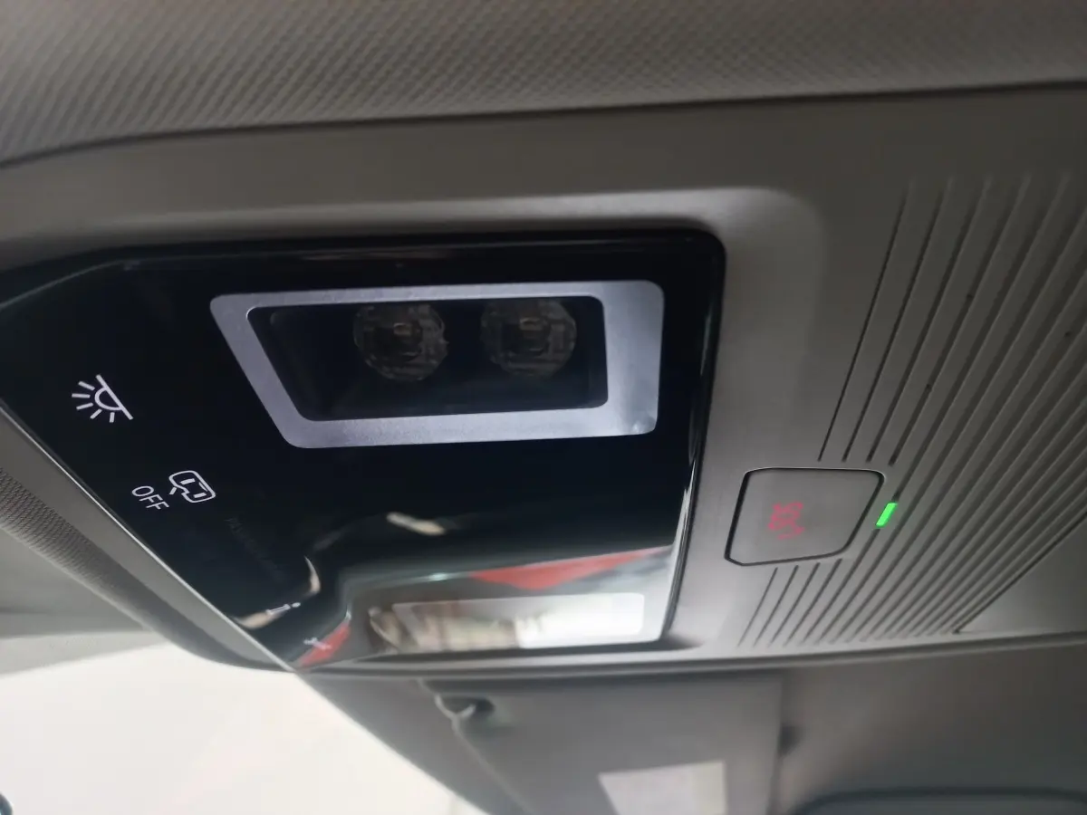 Vue intérieure du plafonnier avec bouton SOS éclairé et commandes d’éclairage dans une Skoda Octavia bleu 2022.