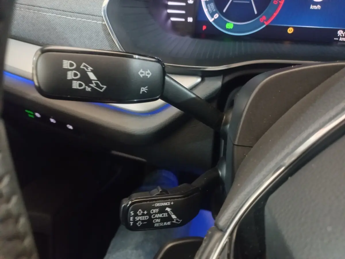 Gros plan sur les commandes au volant de la Skoda Octavia 2022, avec éclairage bleu et tableau de bord numérique.