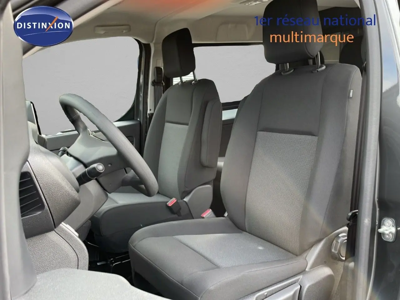 Vue intérieure côté conducteur du Citroën Jumpy Cabine Approfondie gris titane, montrant les sièges avant en tissu gris.