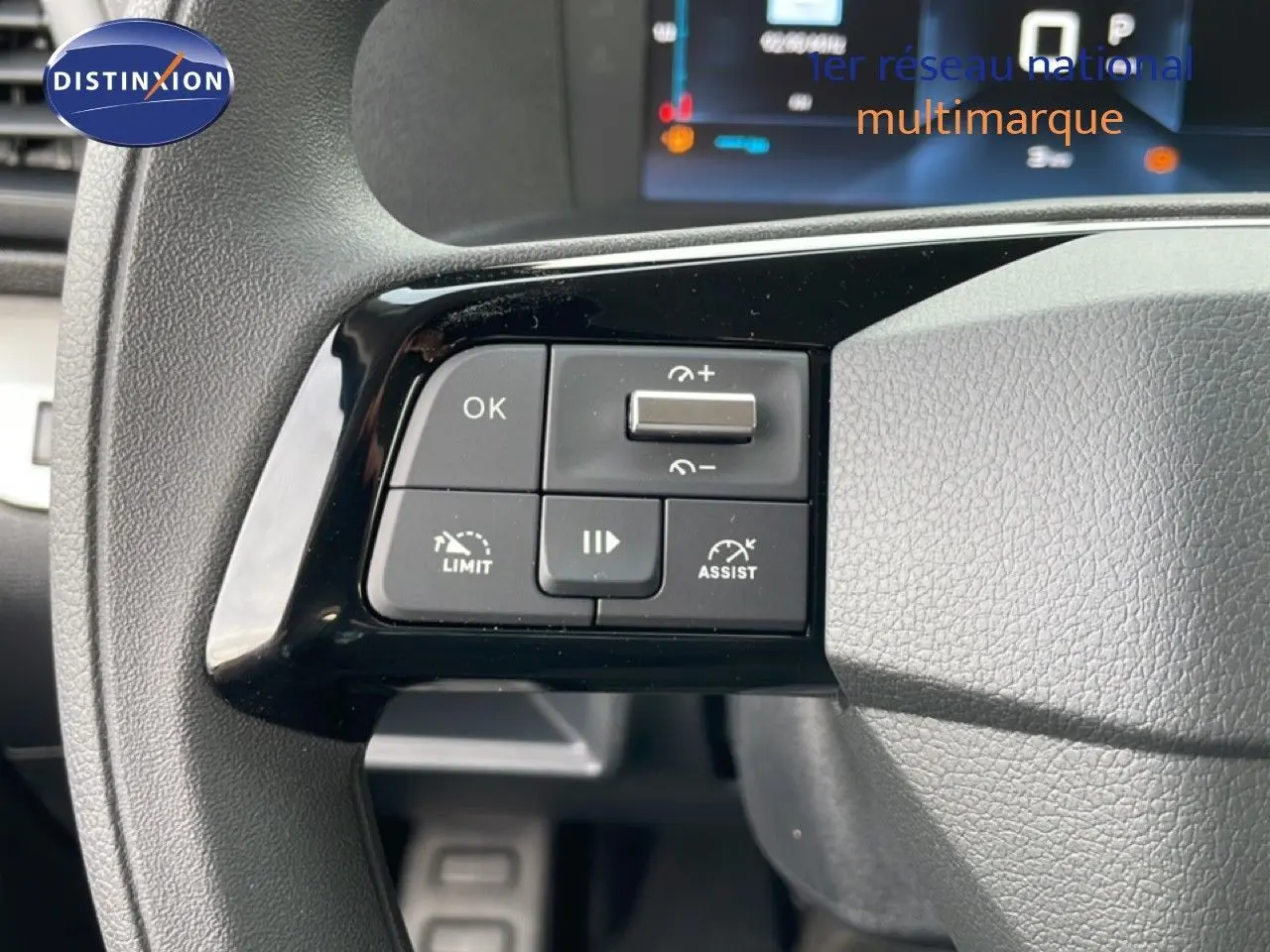 Gros plan sur les commandes au volant du Citroën Jumpy Cabine Approfondie gris titane, avec affichage numérique en arrière-plan.