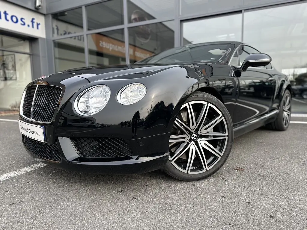 Bentley Continental GT 4.0 V8 Mulliner noire vue en 3/4 avant mettant en valeur ses phares ronds et jantes distinctives.