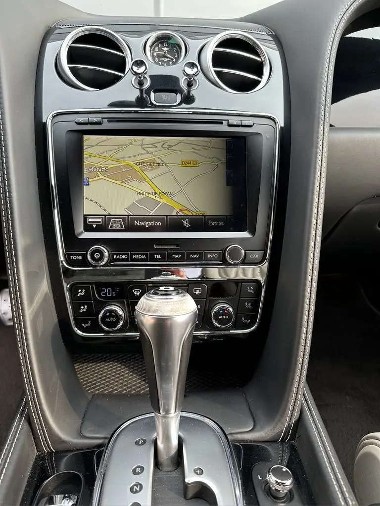 Gros plan sur la console centrale noire de la Bentley Continental GT 4.0 V8 Mulliner 2013 avec écran navigation et levier de vitesse automatique.