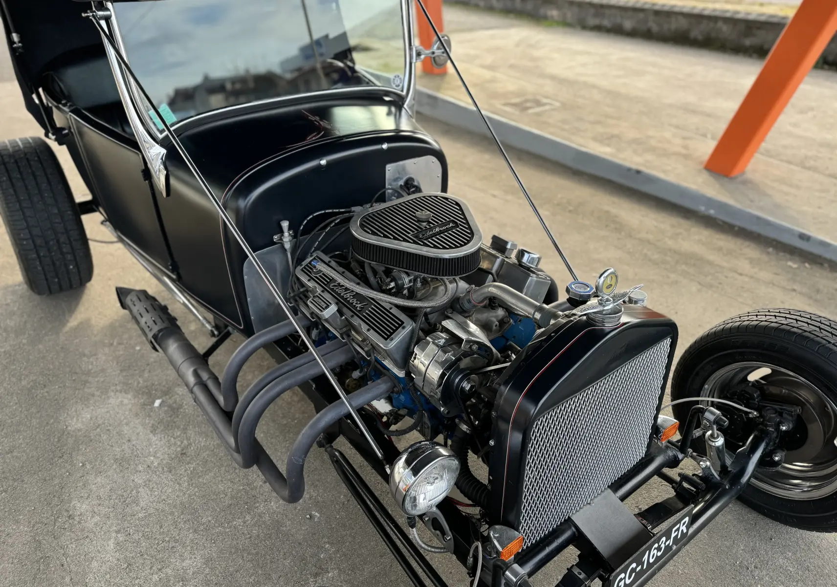 Vue 3/4 avant droit du Ford T Hot Rod V8 noir mat avec moteur V8 apparent et liserés rouges faits à la main.