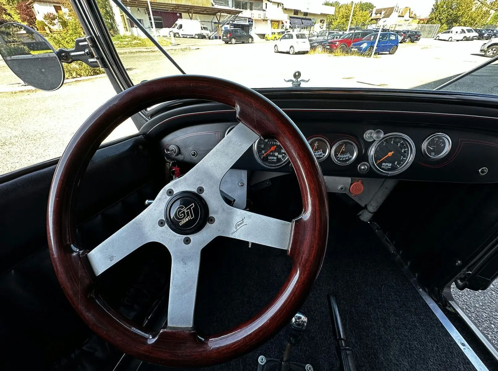 Volant Grant GT bois et tableau de bord noir avec compteurs ronds du Ford T Hot Rod V8 de 1923.