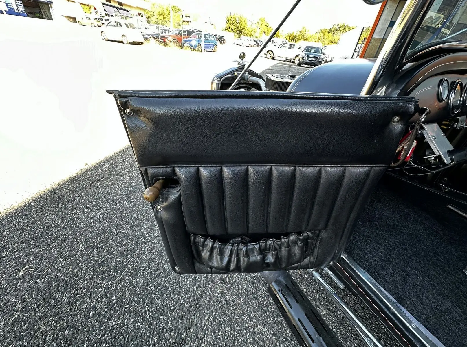 Porte côté gauche en cuir noir matelassé du Ford T Hot Rod V8 1923, avec poignée en bois visible.