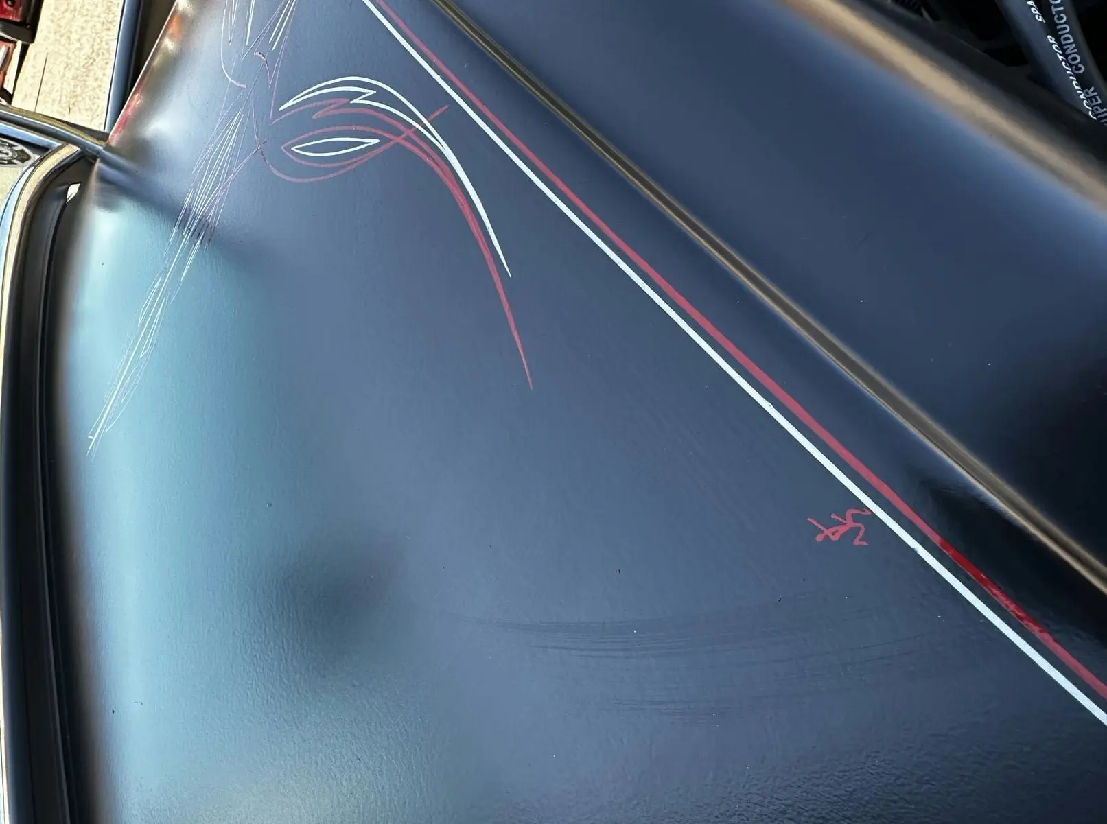 Détail de la peinture noire avec liserés rouges et blancs faits à la main sur le capot d'un Ford T Hot Rod V8 1923.