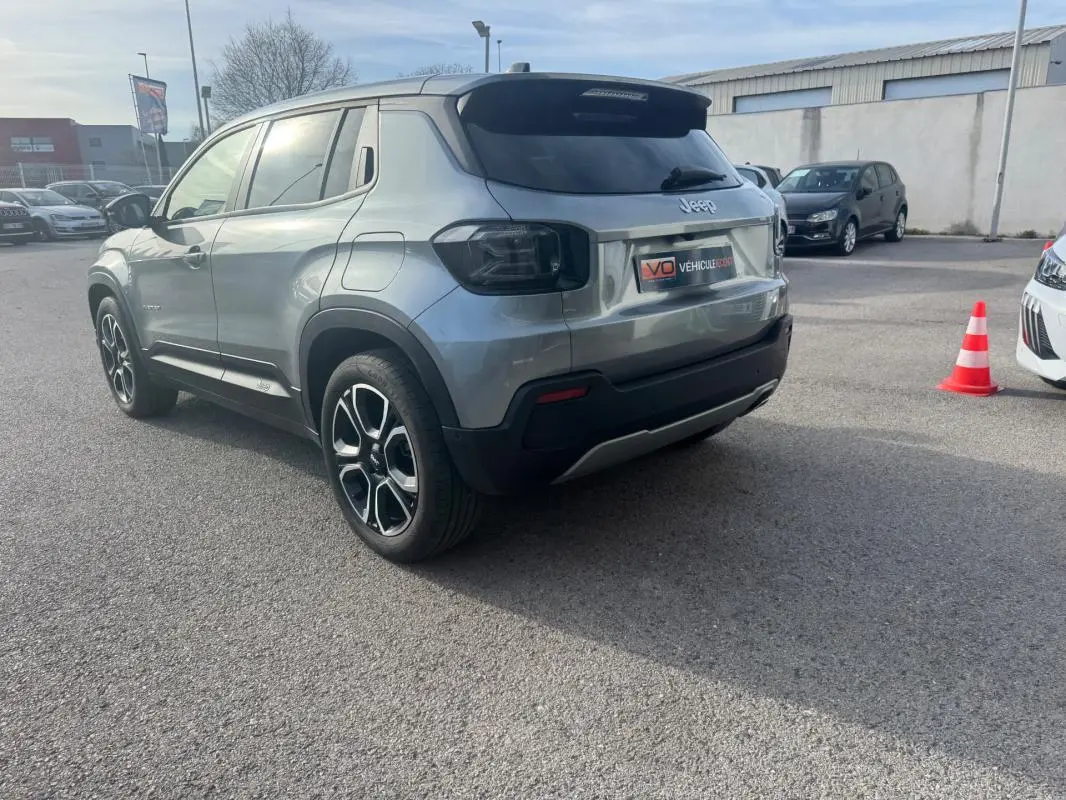 Jeep Avenger gris en vue 3/4 arrière droit, avec jantes alliage 18 pouces et vitres teintées.