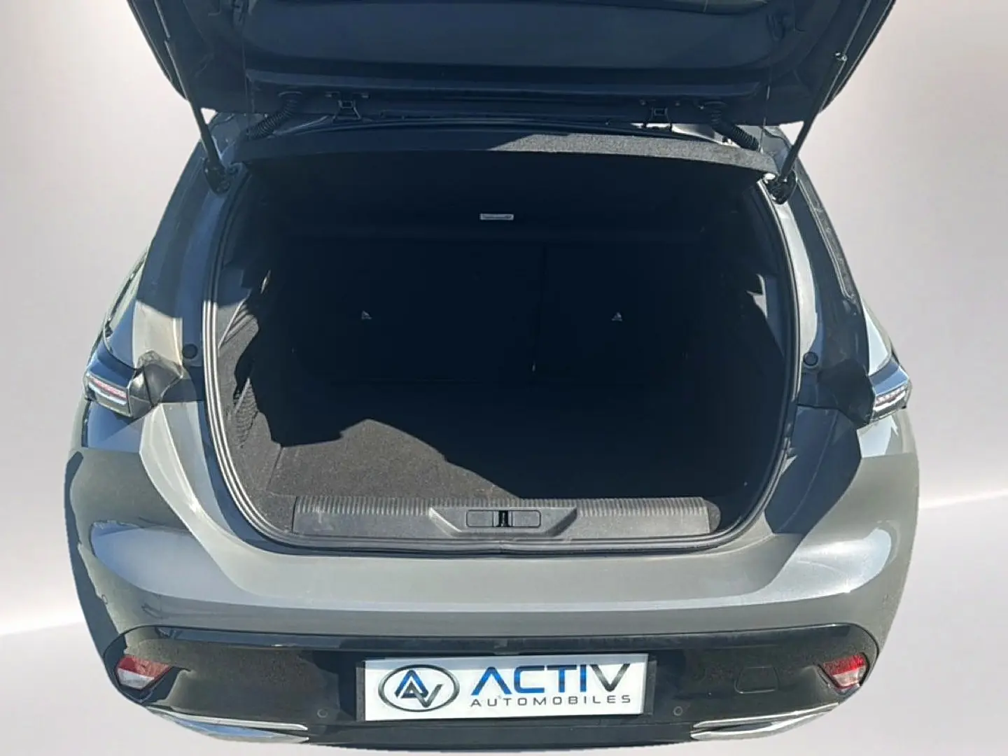 Vue arrière ouverte du coffre d'une Peugeot 308 gris selenium, avec feux arrière LED et plaque Activ Automobiles.