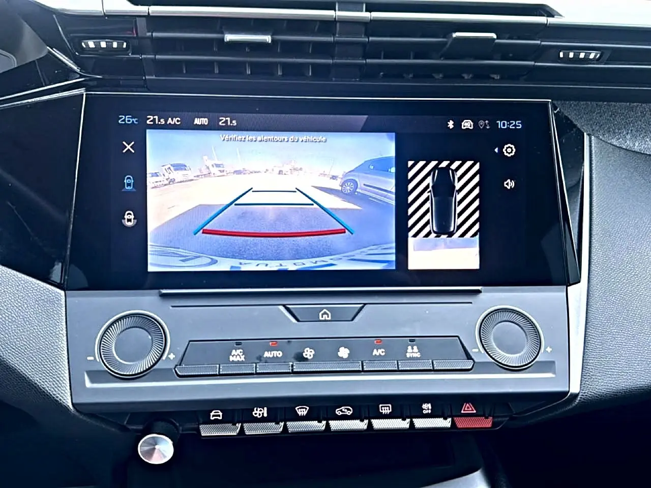 Écran tactile central de la Peugeot 308 2025 montrant la caméra de recul et les commandes climatisation.