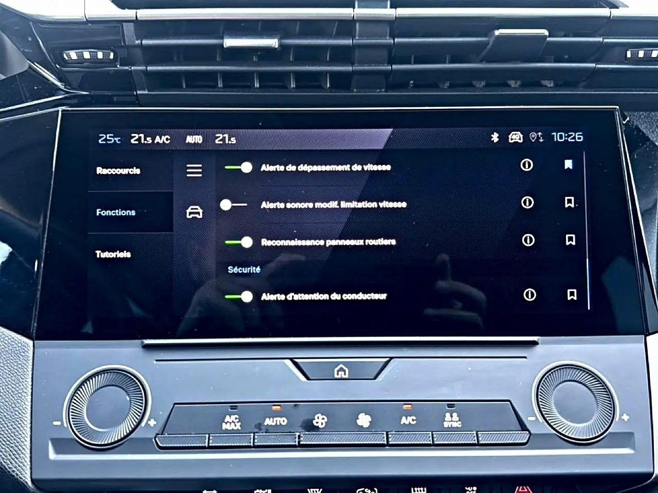 Écran tactile central de la Peugeot 308 2025 affichant les alertes de sécurité, avec commandes climatisation en dessous.