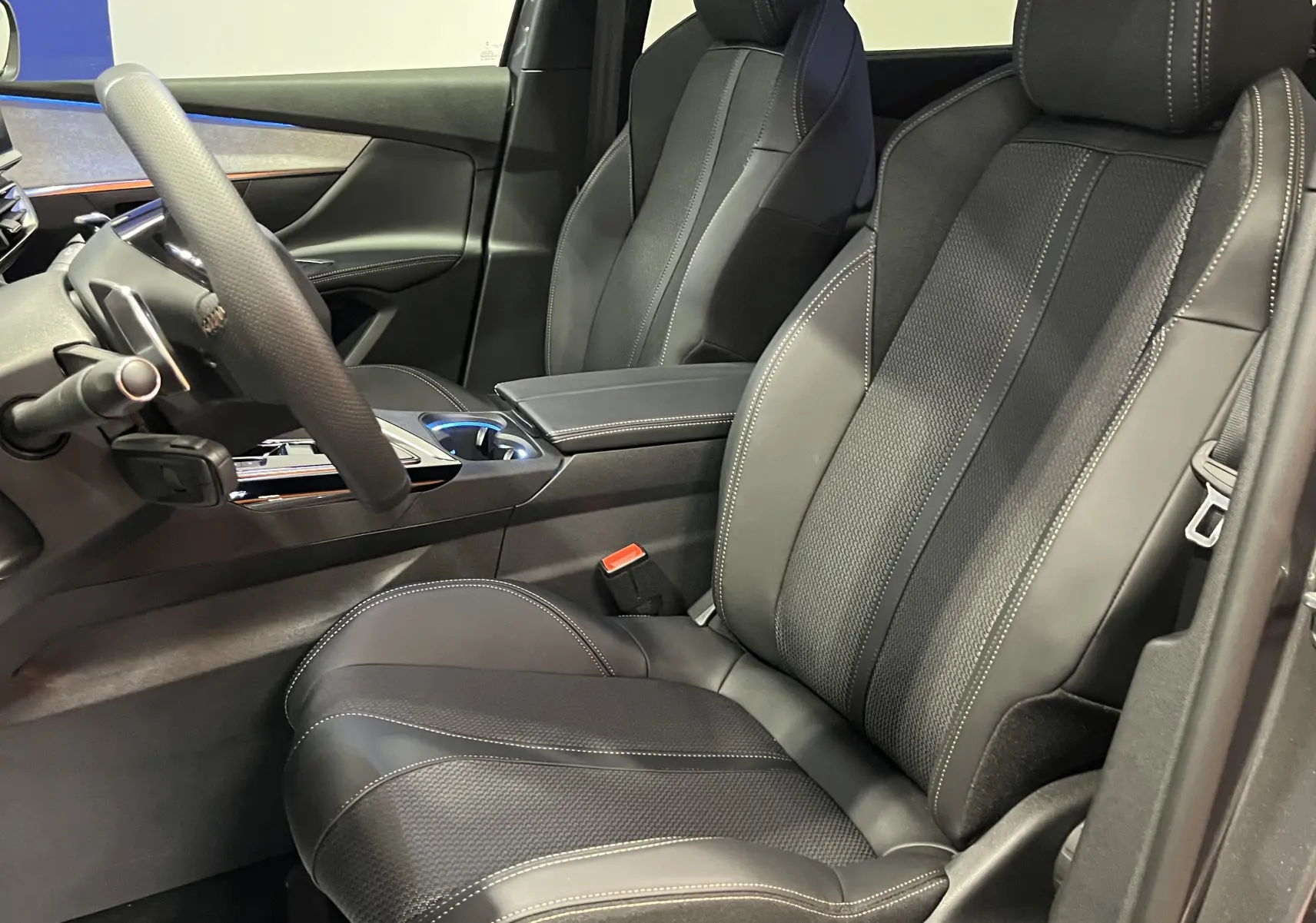 Intérieur du Peugeot 5008 2024 GT, vue côté conducteur montrant les sièges en cuir noir avec surpiqûres contrastantes.