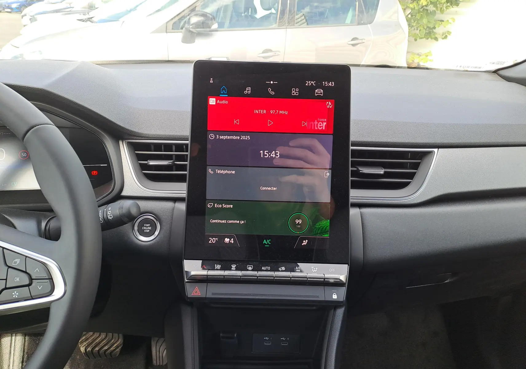 Vue intérieure centrée sur l'écran tactile vertical du tableau de bord du Renault Captur gris rafale 2025.