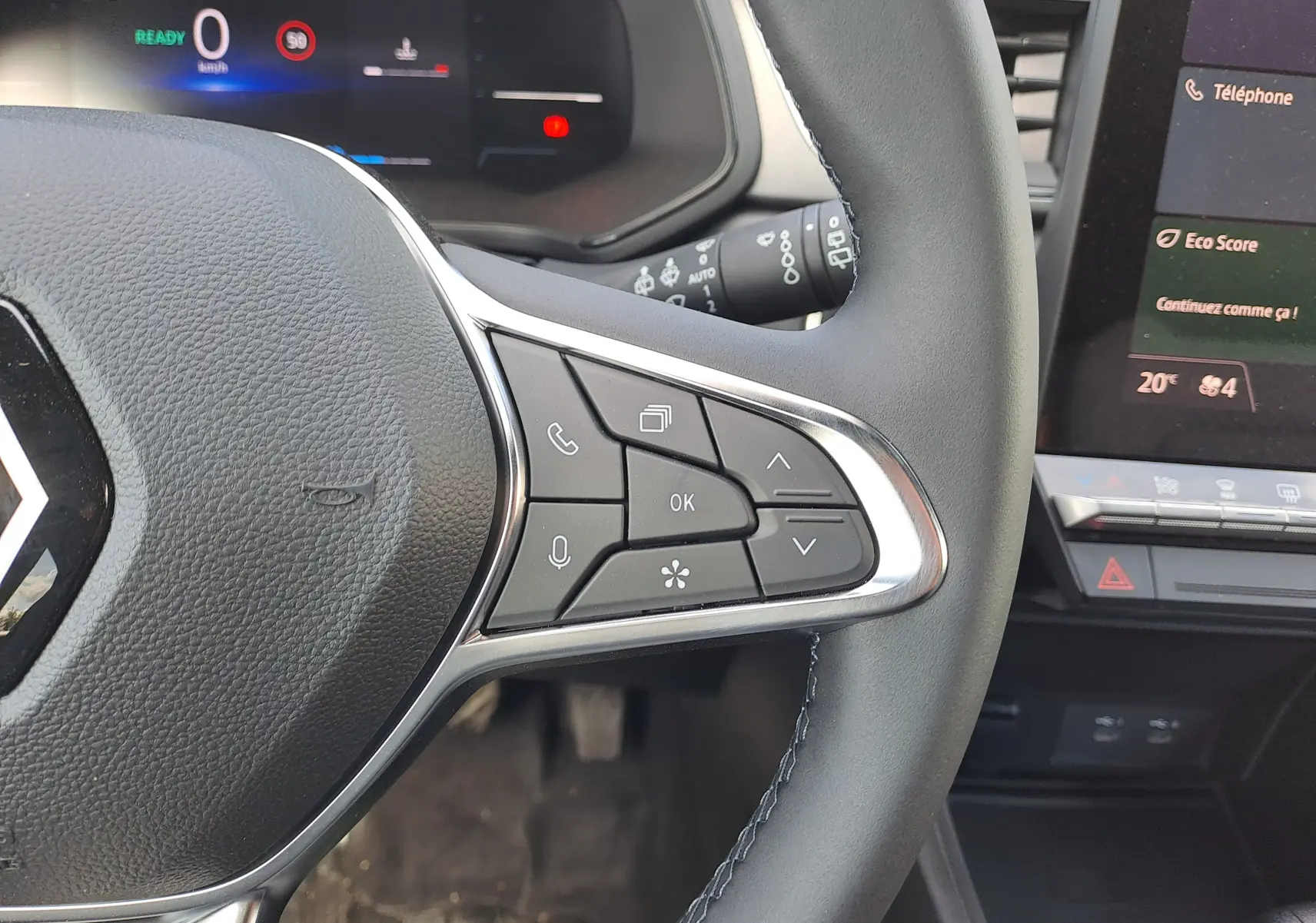 Gros plan sur le côté droit du volant du Renault Captur 2025, avec commandes intégrées et tableau de bord numérique visible.