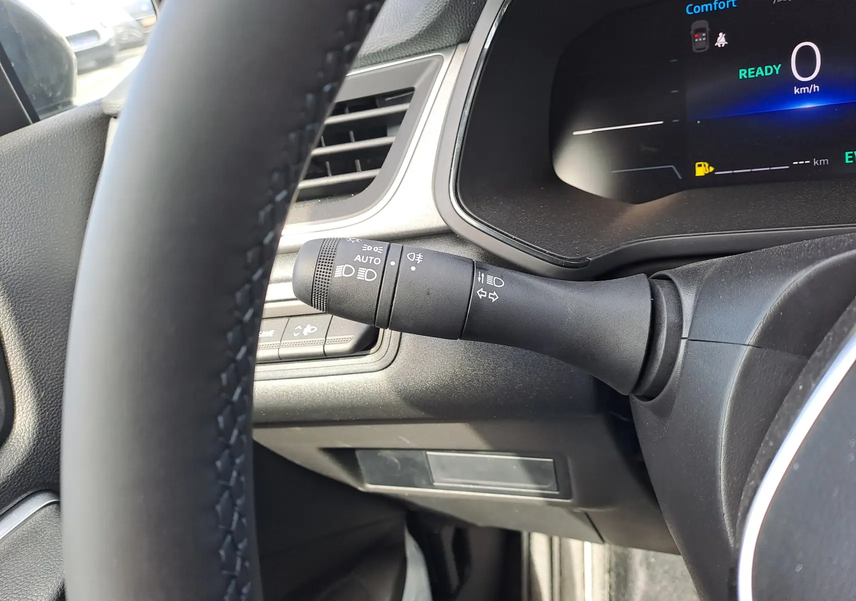 Gros plan sur la manette d'éclairage à gauche du volant dans le tableau de bord du Renault Captur gris Rafale 2025.