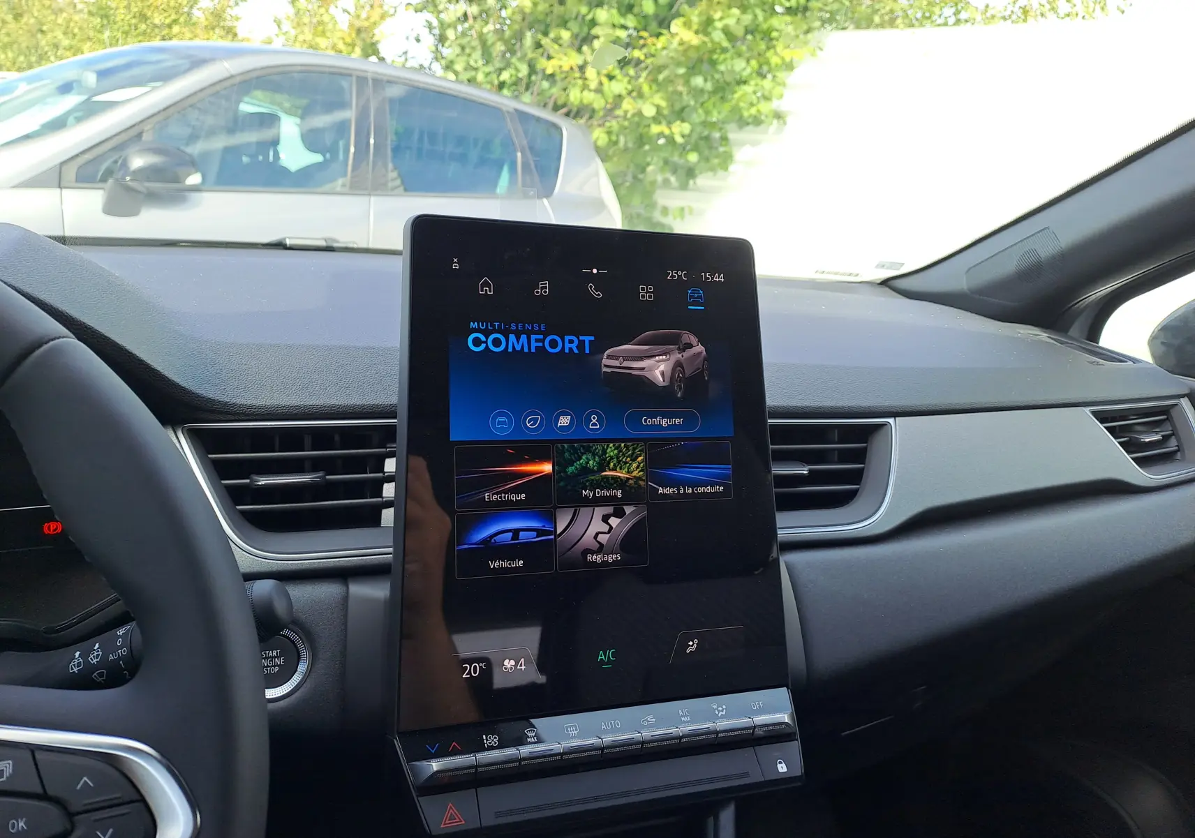 Vue intérieure du tableau de bord du Renault Captur 2025 avec écran tactile vertical et commandes climatisation.