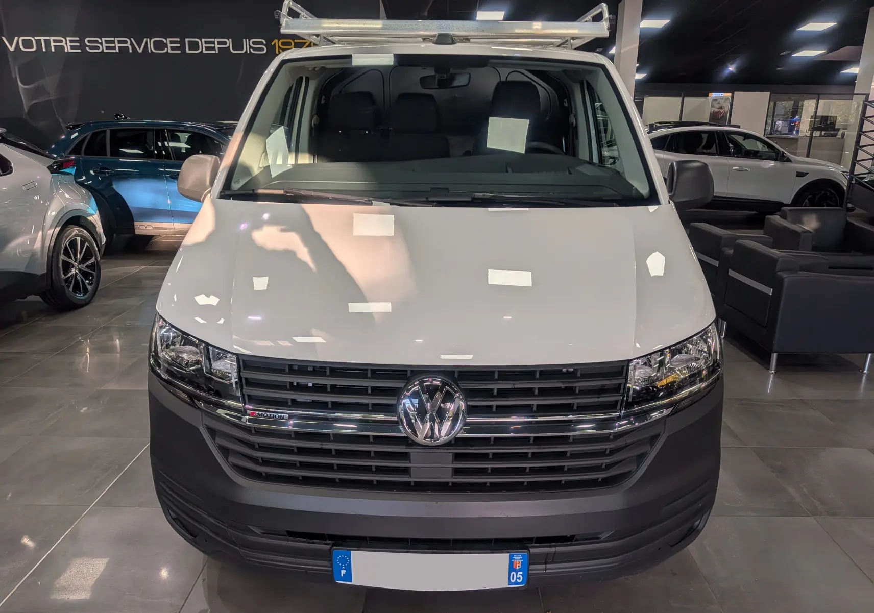 Vue frontale d'un Volkswagen Transporter 6.1 Van blanc Candy avec calandre noire et logo VW chromé.