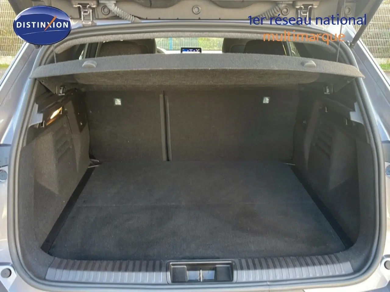 Coffre ouvert d'une Renault SYMBIOZ gris cassiopée métal, vue arrière montrant l'espace de chargement vide et la plage arrière.