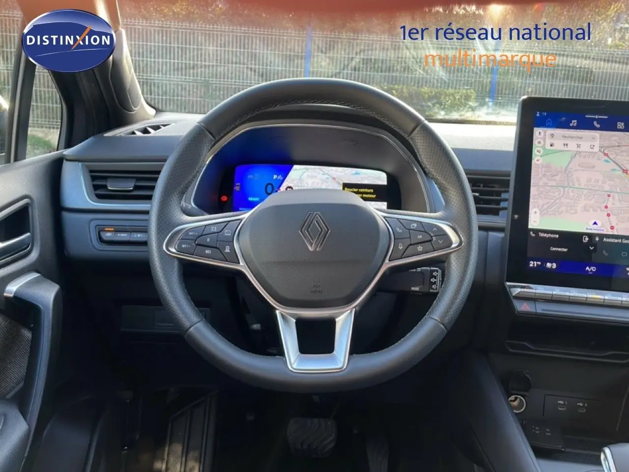 Vue intérieure centrée sur le volant noir et le tableau de bord digital du Renault Symbioz gris Cassiopée 2025.