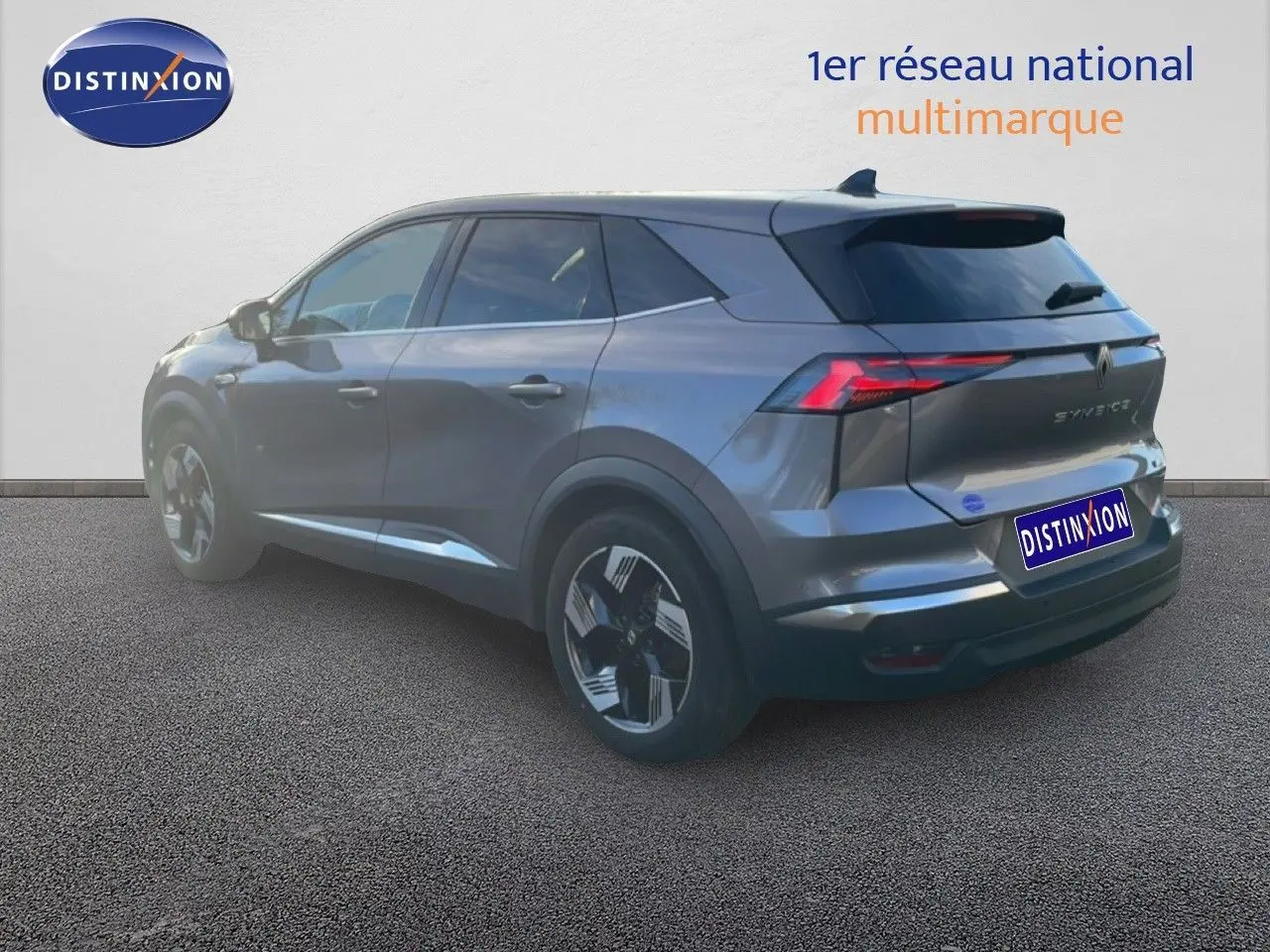 Renault Symbioz gris cassiopée métal vu en 3/4 arrière droit, soulignant ses feux LED et lignes modernes.