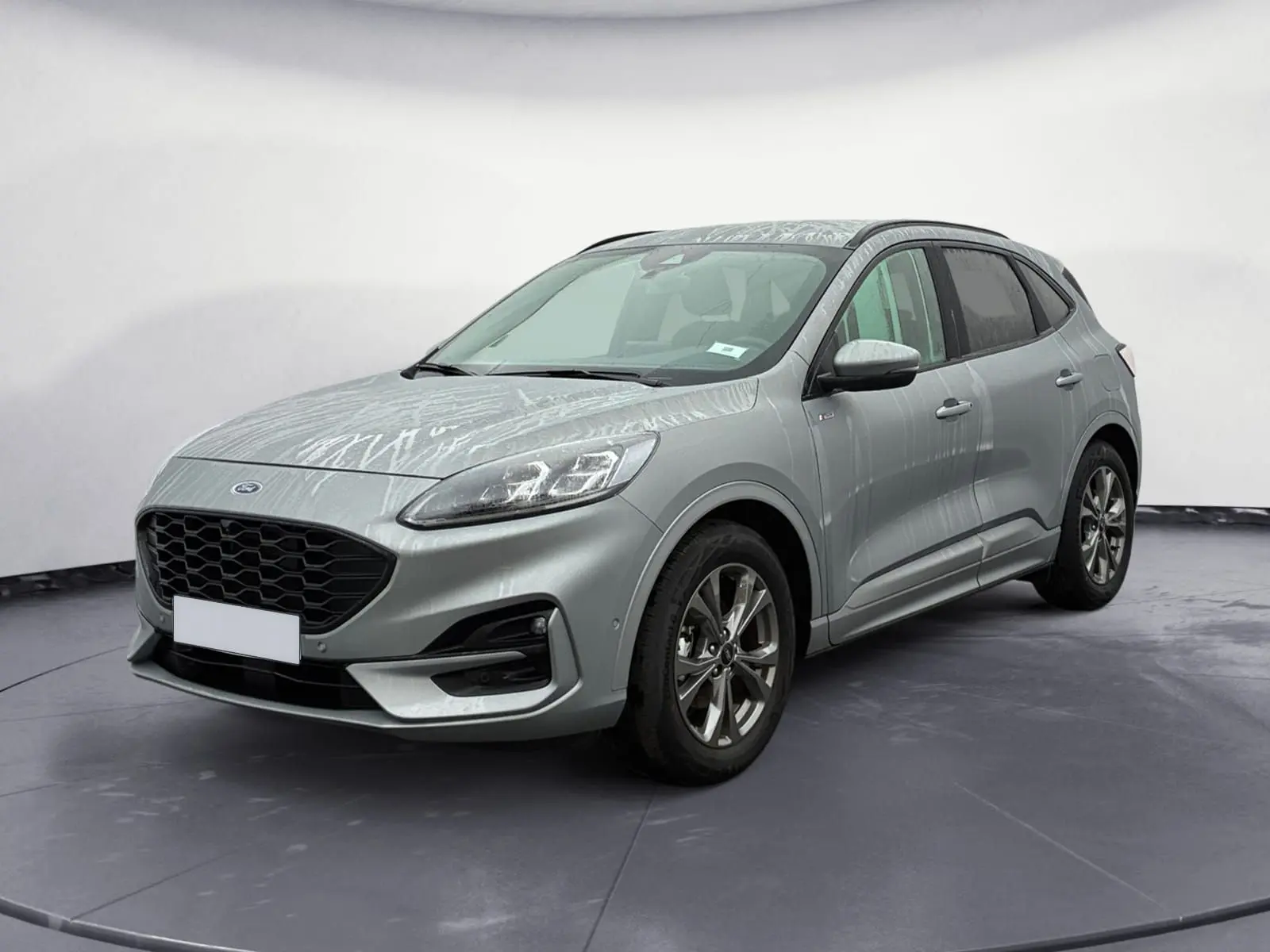 Vue 3/4 avant droit du Ford Kuga 2024 gris, version hybride ST-Line X avec calandre noire et jantes alliage.