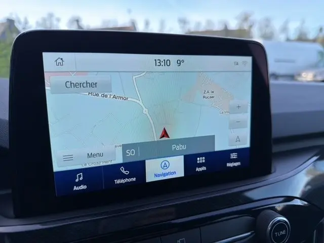 Écran tactile du système de navigation du Ford Kuga 2024, affichant une carte avec interface moderne.