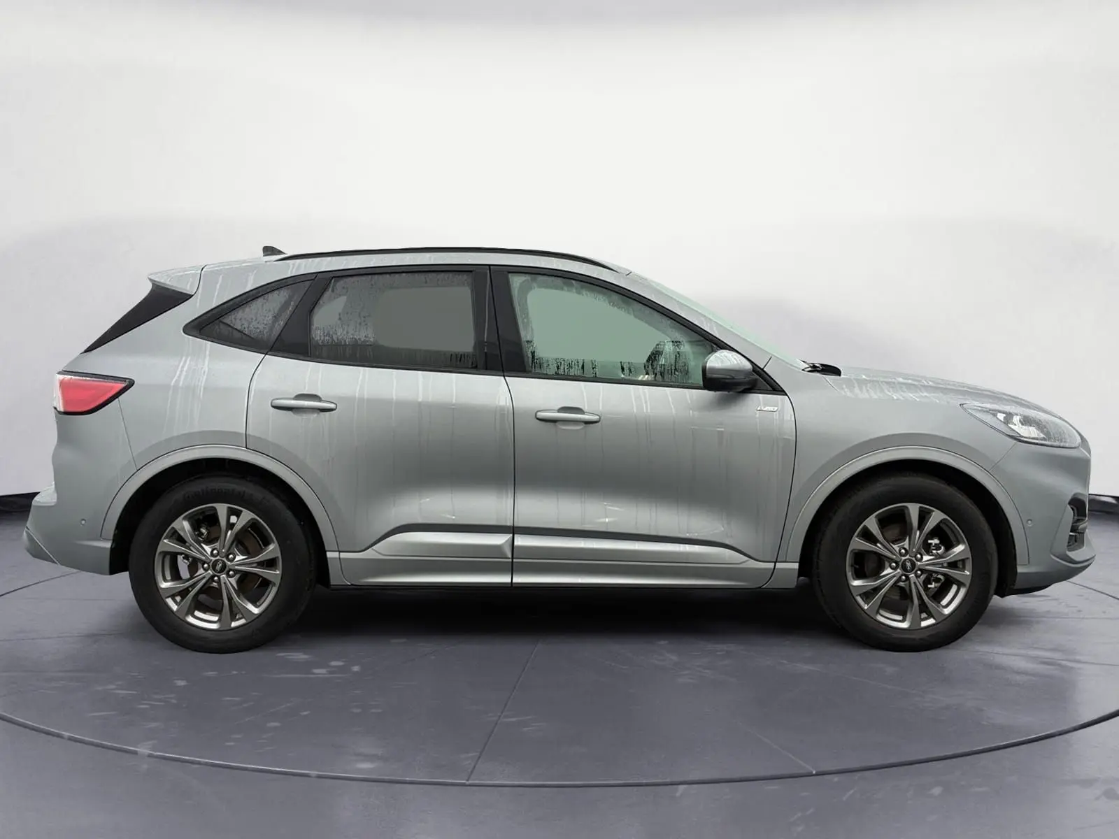 Profil droit d’un Ford Kuga gris 2024 hybride essence, avec jantes alliage et lignes dynamiques ST-Line X.