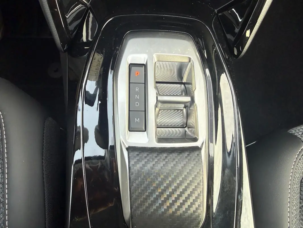 Gros plan sur la console centrale noire brillante avec sélecteur de vitesses automatique de la Peugeot 208 Hybrid 110.