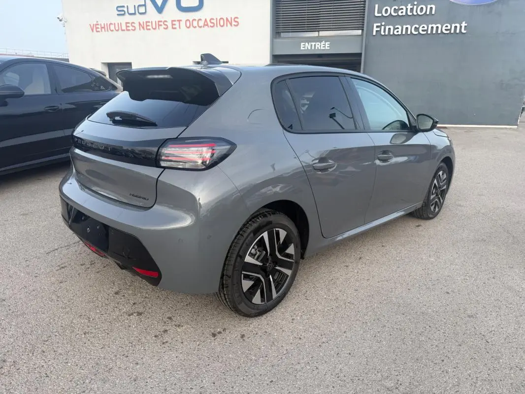 Vue 3/4 arrière droite d'une Peugeot 208 Hybrid 110 gris métallisé avec jantes alliage 16 pouces et antenne requin.
