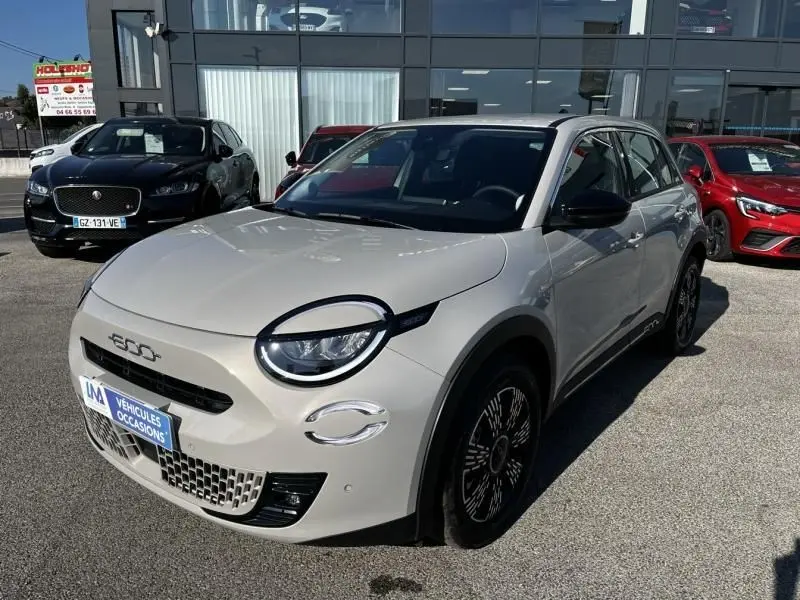 Vue 3/4 avant droite d'une FIAT 600 T-Gen 3 beige 2025 avec phares ronds et jantes noires distinctives.