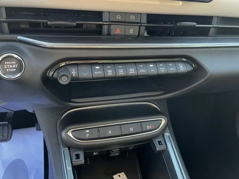 Vue rapprochée de la console centrale noire du Fiat 600 T-Gen 3 2025 avec boutons de climatisation et boîte auto.