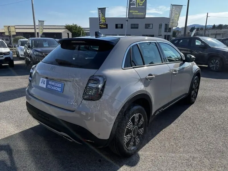 Vue 3/4 arrière droite d'une FIAT 600 T-Gen 3 beige 2025 avec feux arrière sombres et jantes au design moderne.