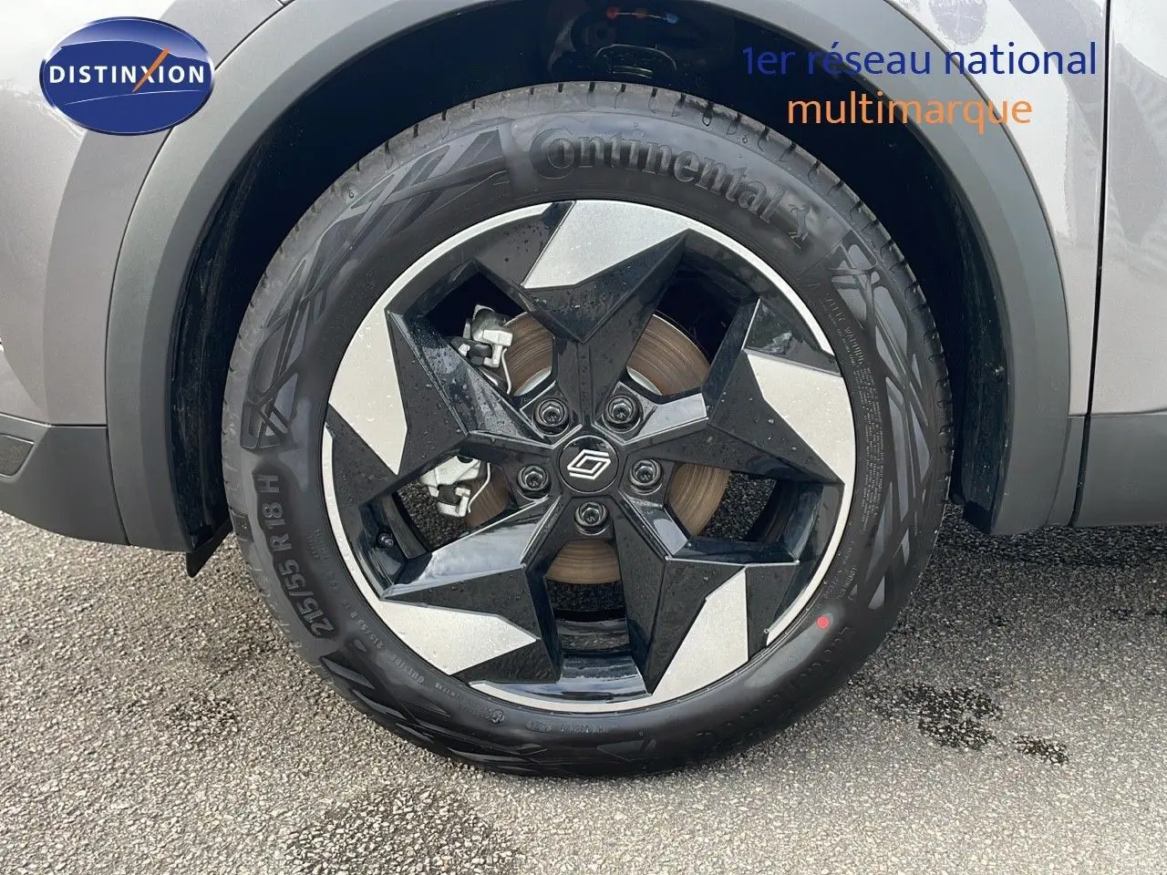 Gros plan sur la roue avant gauche du Renault Captur gris Cassiopée métal avec jante noire et argentée design étoile.