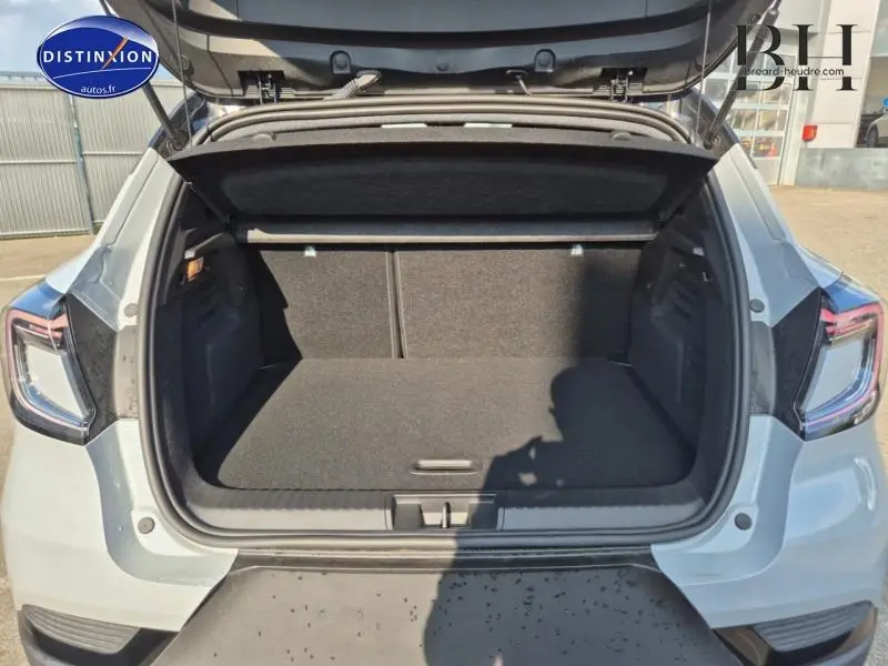 Coffre ouvert vu de l'arrière d'un Renault Captur 2025 gris Rafale avec intérieur noir et feux arrière LED.
