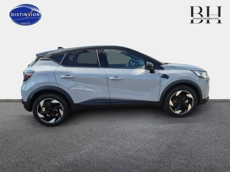 Profil droit du Renault Captur 2025 hybride gris Rafale avec toit noir et jantes alu distinctives.