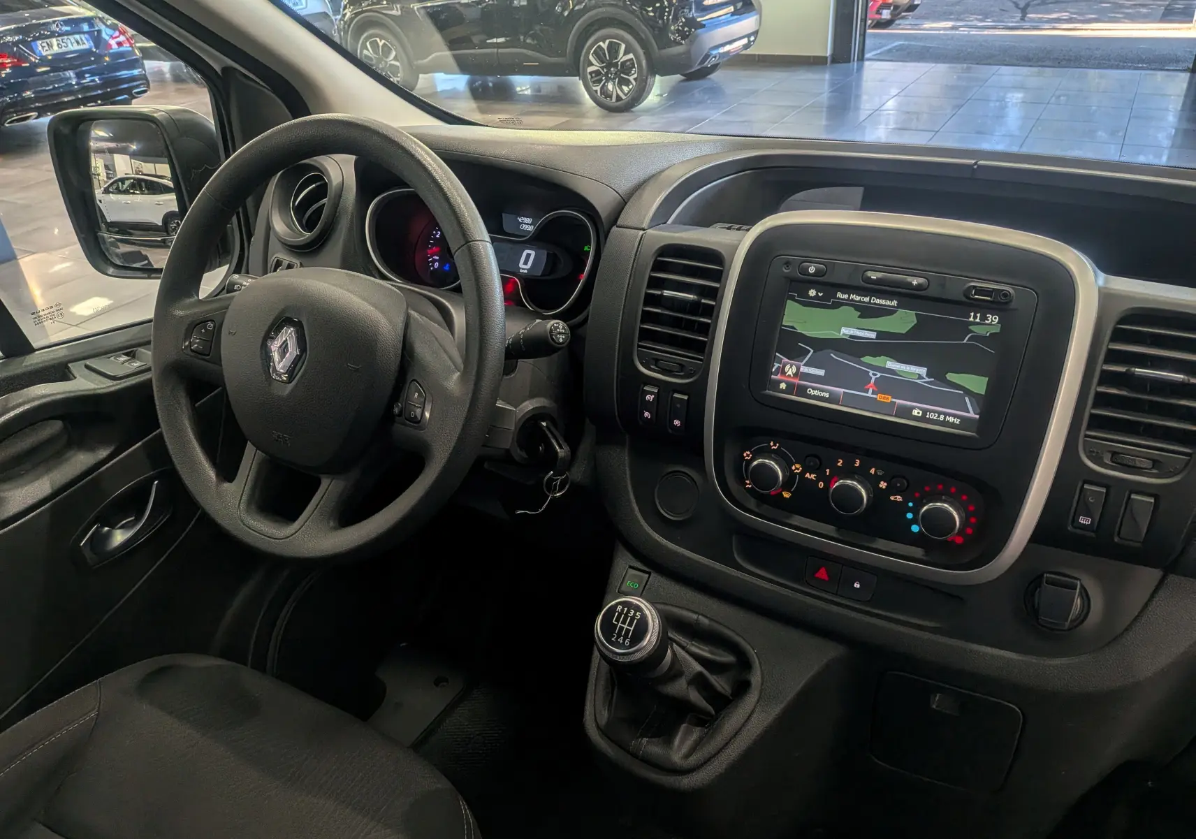 Intérieur du Renault Trafic Fourgon L2H2 2021, vue du poste de conduite avec tableau de bord et écran GPS intégré.