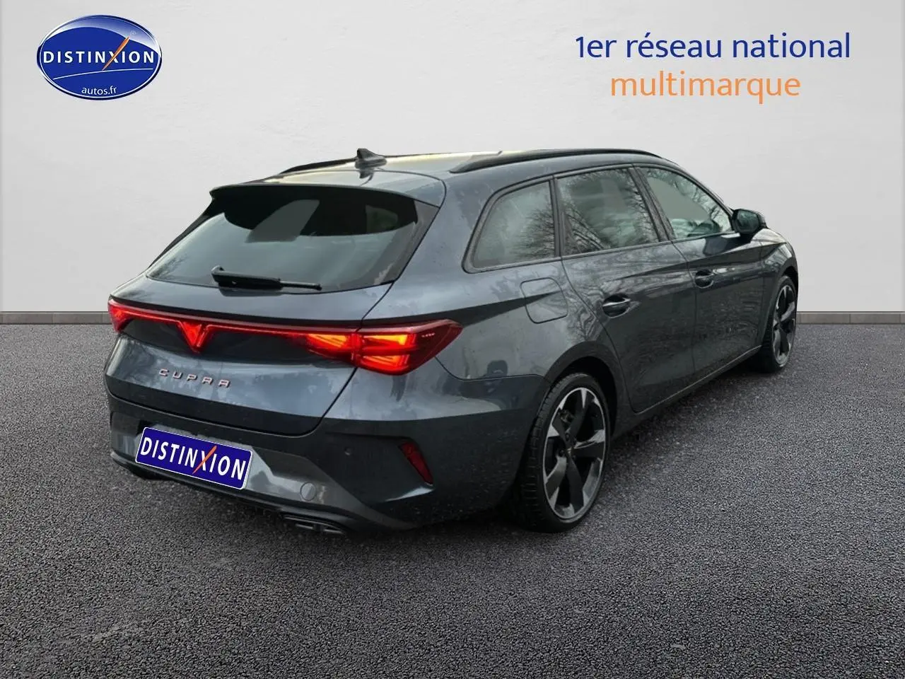 Vue 3/4 arrière droite d'une CUPRA Leon ST 2025 gris magnétique avec feux arrière LED allumés et jantes alu noires.