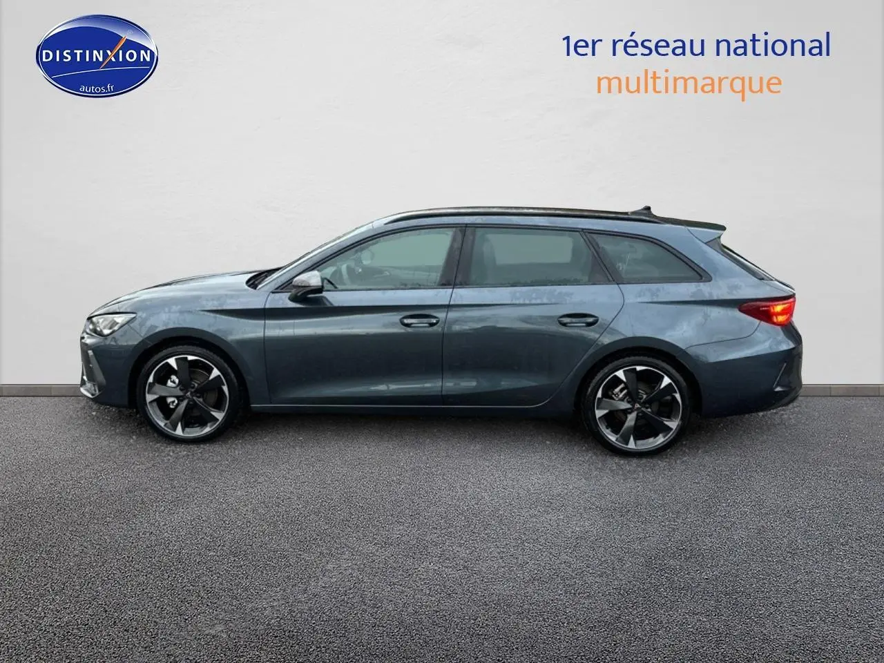 Vue latérale droite de la CUPRA Leon ST 2025 gris magnétique avec jantes alu noires et feux arrière allumés.