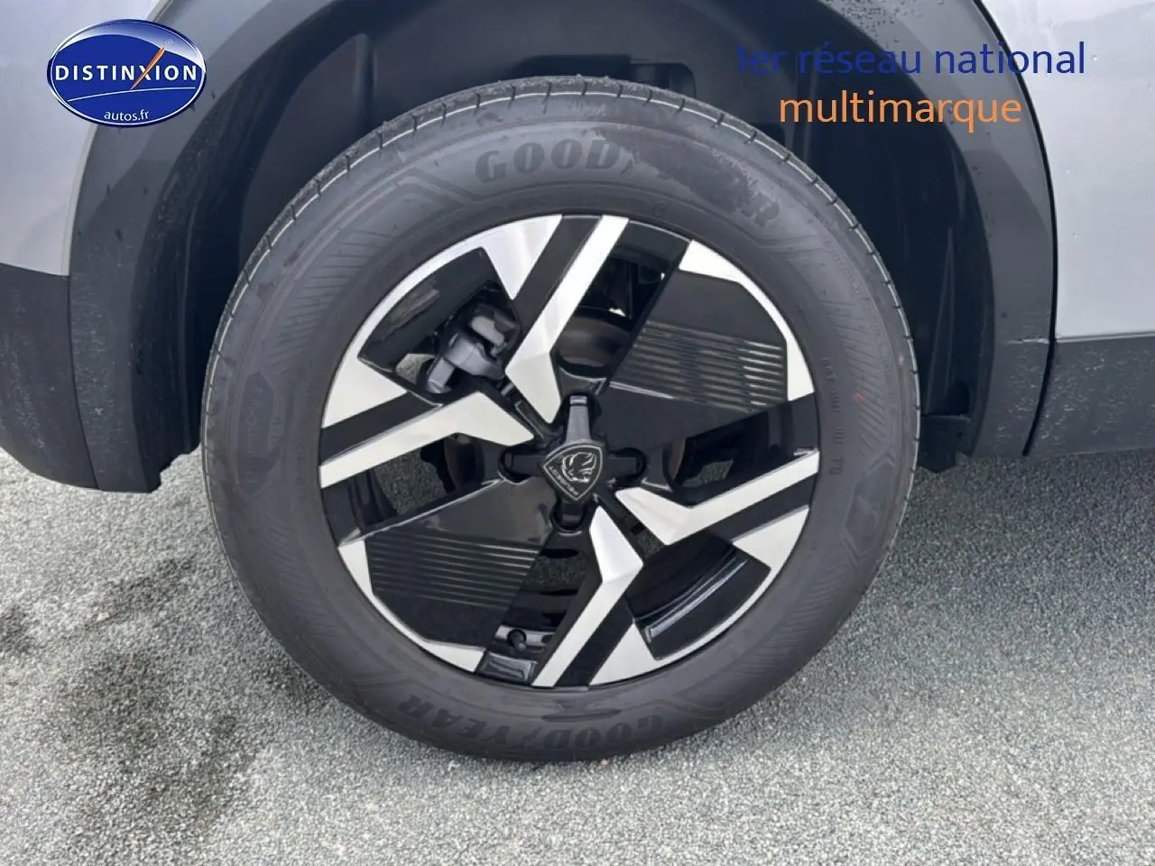 Gros plan sur la roue avant gauche avec jante alu bicolore du Peugeot 2008 gris artense 2025.