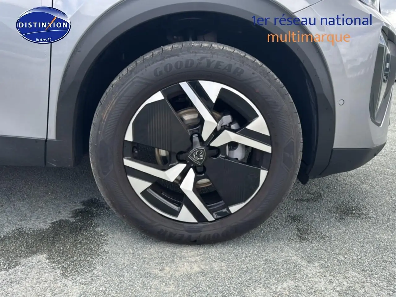 Gros plan sur la roue avant droite avec jante alu noire et argentée du Peugeot 2008 gris artense.