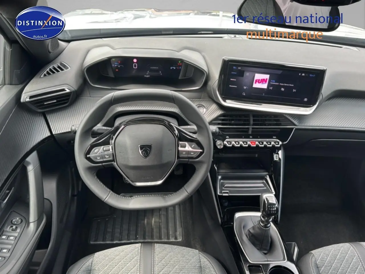 Vue intérieure frontale du poste de conduite du Peugeot 2008 gris Artense, avec volant multifonction et écran tactile central.