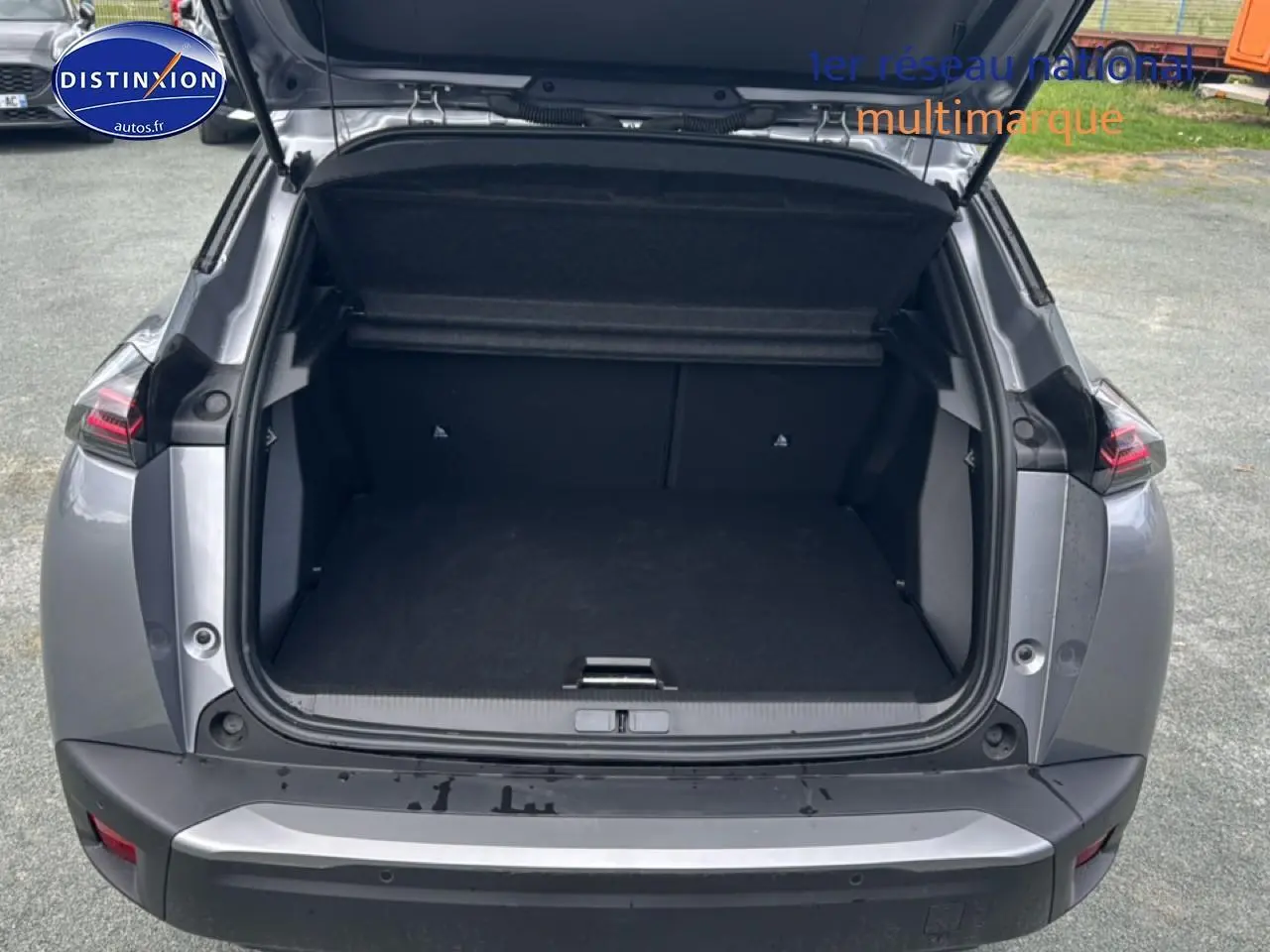 Vue arrière ouverte du Peugeot 2008 gris artense montrant le coffre spacieux et les feux arrière LED.