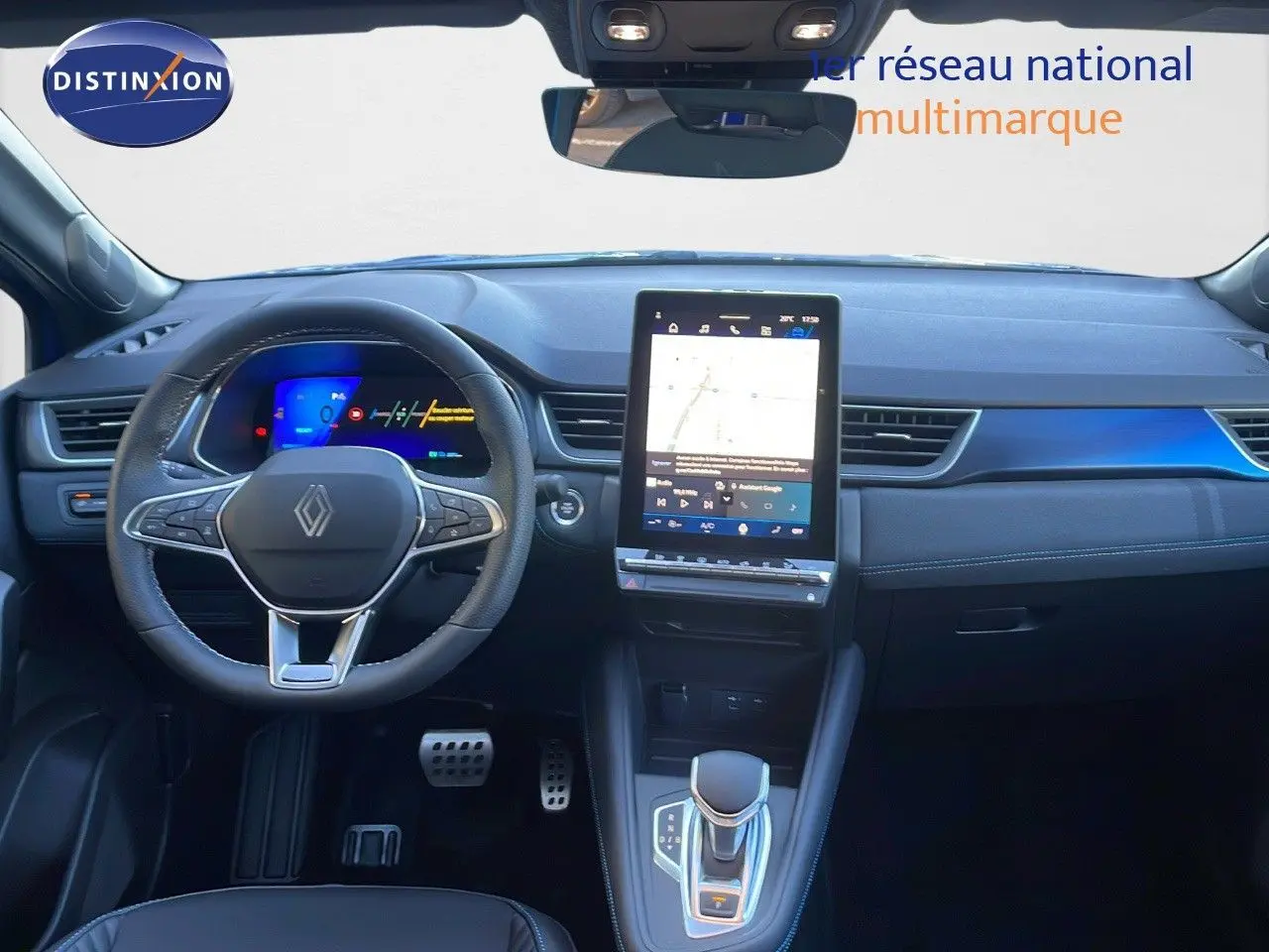 Vue intérieure avant du tableau de bord et volant noir de la Renault Symbioz 1.6 E-TECH hybride avec écran tactile central vertical.