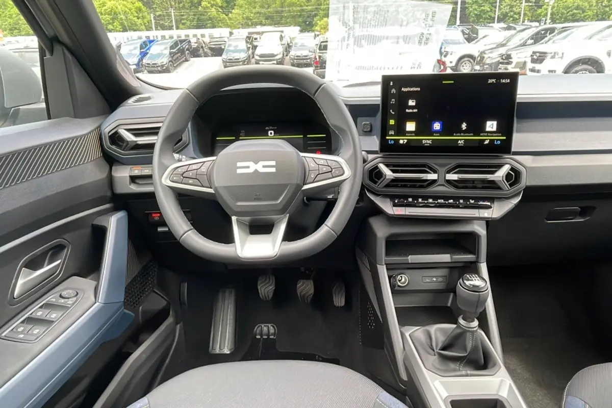 Vue intérieure centrée sur le volant cuir et la console avec écran tactile du DACIA BIGSTER 2025.