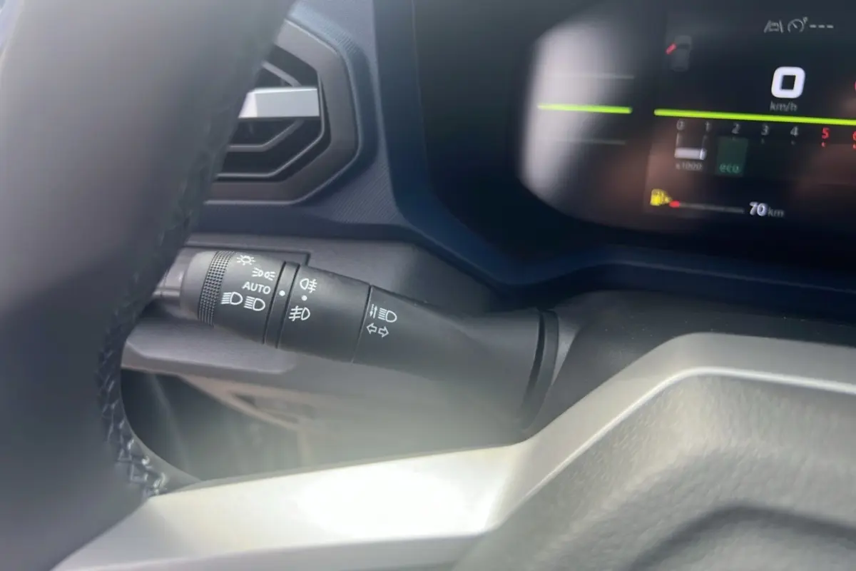 Gros plan sur la commande des feux et clignotants du tableau de bord du Dacia Bigster 2025, intérieur noir.